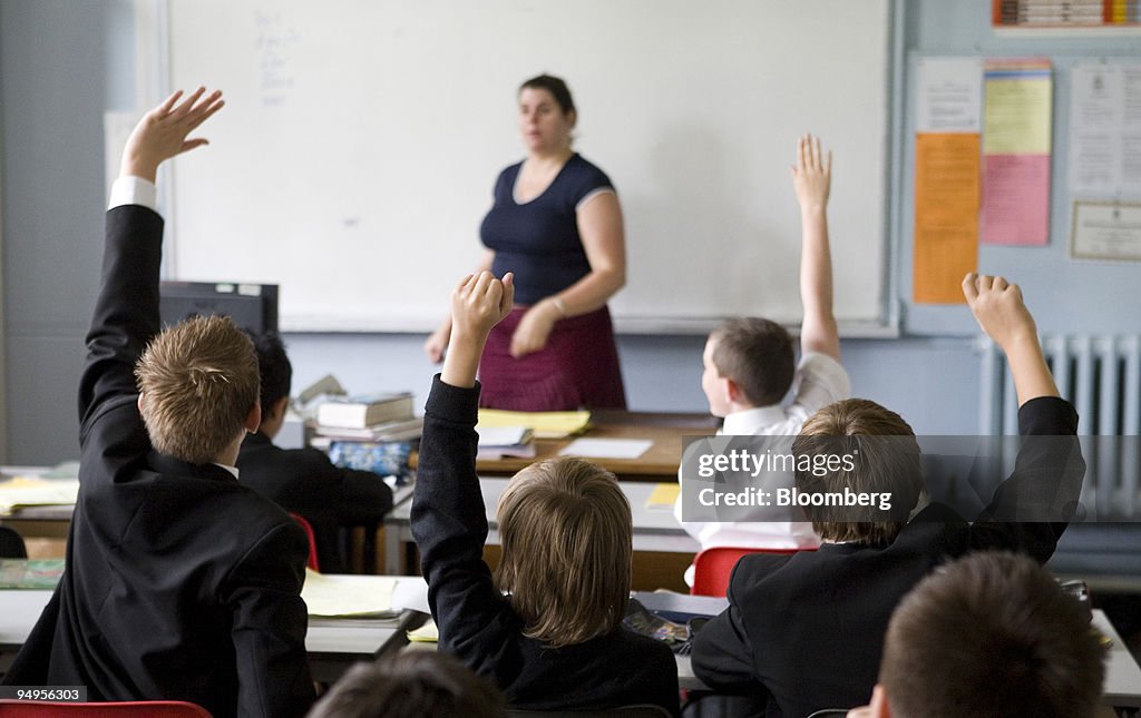 Pupils put their hands in the air to answer a question durin