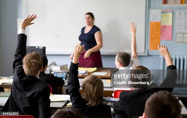 Pupils put their hands in the air to answer a question during a German lesson at Maidstone Grammar school, Maidstone, U.K., on Friday, June 12, 2009....