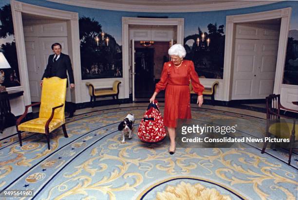 First Lady Barbara Bush walks her pet dog, Millie , through the White House's Diplomatic Reception Room, Washington DC, March 24, 1989.