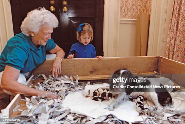 In the White House, First Lady Barbara Bush and her granddaughter, Marshall Lloyd Bush, look at the Bush's pet dog Millie and her litter of puppies,...