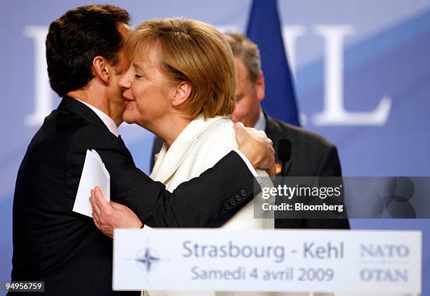 Nicolas Sarkozy, France's president, left, kisses Angela Merkel, Germany's chancellor, at a news conference after a North Atlantic Treaty...