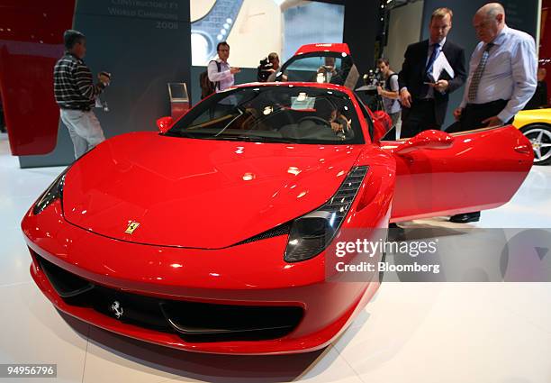 Visitors look at a Ferrari 458 Italia automobile on the second press day of the Frankfurt Motor Show, in Frankfurt, Germany, on Wednesday, Sept. 16,...