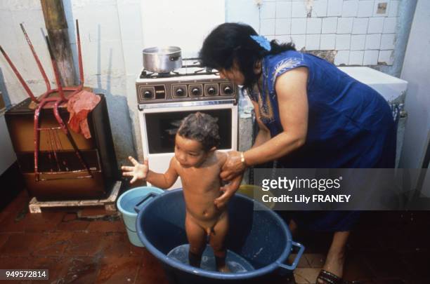 Femme donnant le bain à son fils à Marseille, dans les Bouches-du-Rhône, France.