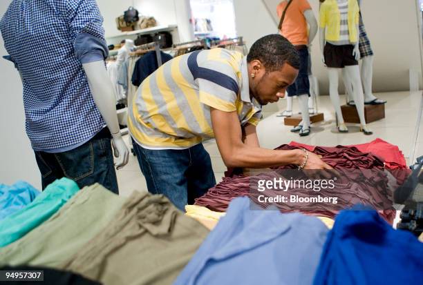 Employee Everton Mckenzie arranges clothing at a Gap Inc. Store in New York, U.S., on Thursday, May 21, 2009. Gap earnings will be released after the...