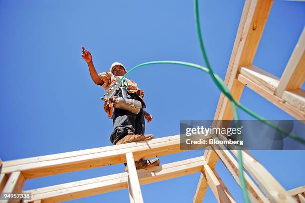 Nicolas Ramos asks for a box of nails as he frames the second floor of a home under construction in Alpharetta, Georgia, U.S., on Friday, March 20,...