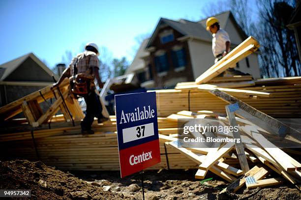 Workers prepare a delivery of lumber to a new home site in Alpharetta, Georgia, U.S., on Friday, March 20, 2009. The deepening economic slump...