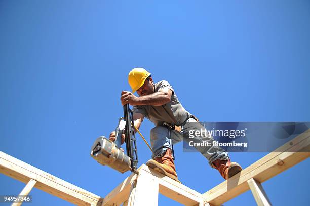 Tomas Martinez frames the second floor of a home under construction in Alpharetta, Georgia, U.S., on Friday, March 20, 2009. The deepening economic...