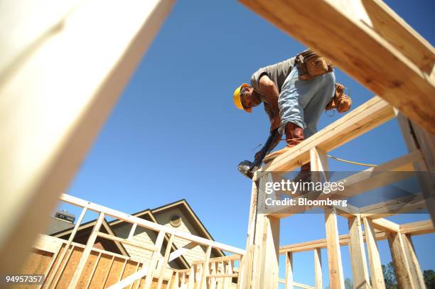 Tomas Martinez frames the second floor of a home under construction in Alpharetta, Georgia, U.S., on Friday, March 20, 2009. The deepening economic...