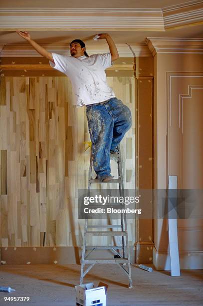 Juan Contreras caulks a wall in preparation for painting a new home in Alpharetta, Georgia, U.S., on Friday, March 20, 2009. The deepening economic...