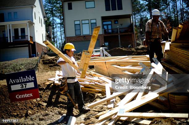 Workers prepare a delivery of lumber to a new home site in Alpharetta, Georgia, U.S., on Friday, March 20, 2009. The deepening economic slump...