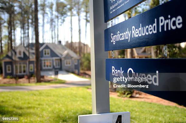 For sale sign advertising a reduced price on a bank owned home stands in Smyrna, Georgia, U.S., on Saturday, March 21, 2009. The deepening economic...