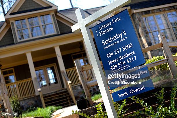 For sale sign advertising a reduced price on a bank owned home stands in Smyrna, Georgia, U.S., on Saturday, March 21, 2009. The deepening economic...