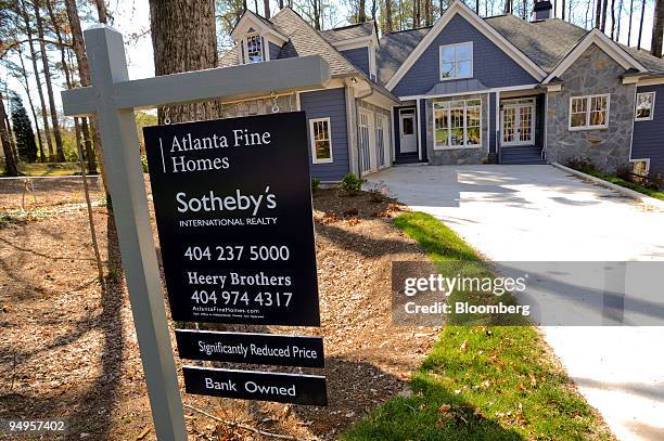 For sale sign advertising a reduced price on a bank owned home stands in Smyrna, Georgia, U.S., on Saturday, March 21, 2009. The deepening economic...