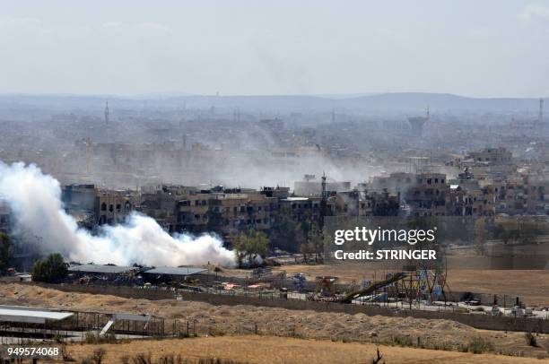 Picture taken on April 21 shows smoke billowing from the Palestinian camp of Yarmuk during regime strikes targeting the Islamic State group in the...