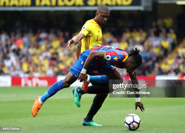 Wilfried Zaha of Crystal Palace goes to ground after a challenge from Abdoulaye Doucoure of Watford during the Premier League match between Watford...