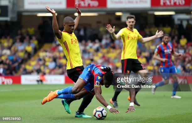 Wilfried Zaha of Crystal Palace goes to ground after a challenge from Abdoulaye Doucoure of Watford during the Premier League match between Watford...