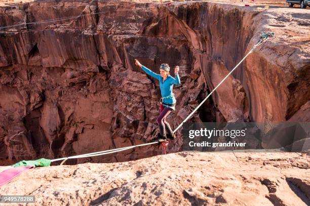 vrouwelijke extreme atleet highlining of slacklining in de buurt van moab, utah - tightrope stockfoto's en -beelden