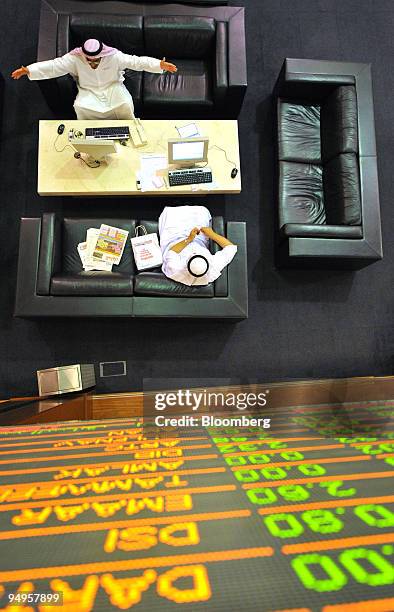 Investors check their stocks while on the floor at the Dubai Financial Market, at the Dubai World Trade Centre, in Dubai, United Arab Emirates, on...