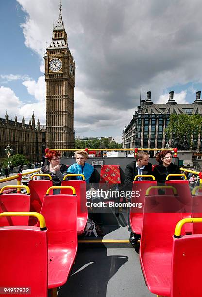 Tourists taking an open top bus tour drive past 'Big Ben' in London, U.K., on Thursday, May 21, 2009. Tourism is wrestling with falling demand as...