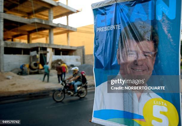 Man rides his motorbike past a poster of Paraguay's presidential candidate for the National Alliance, Efrain Alegre, in Asuncion, on April 21 on the...