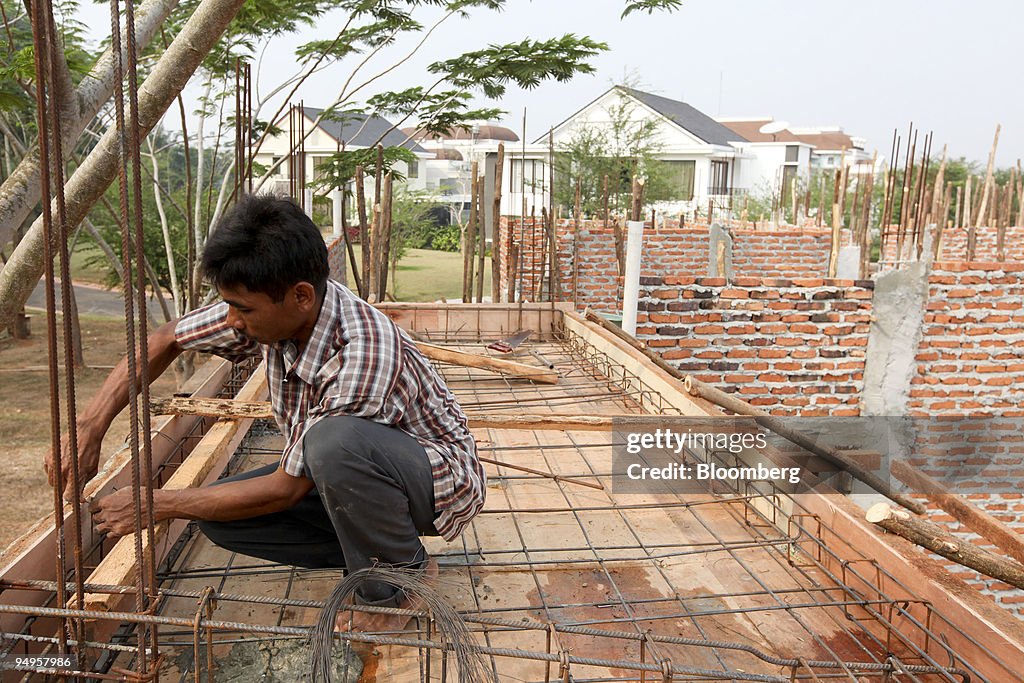 A construction worker labors on the building site of residen