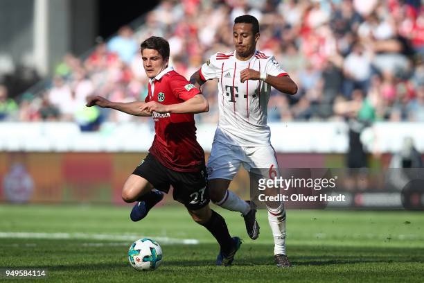 Pirmin Schwegler of Hannover and Thiago of Munich compete for the ball during the Bundesliga match between Hannover 96 and FC Bayern Muenchen at...