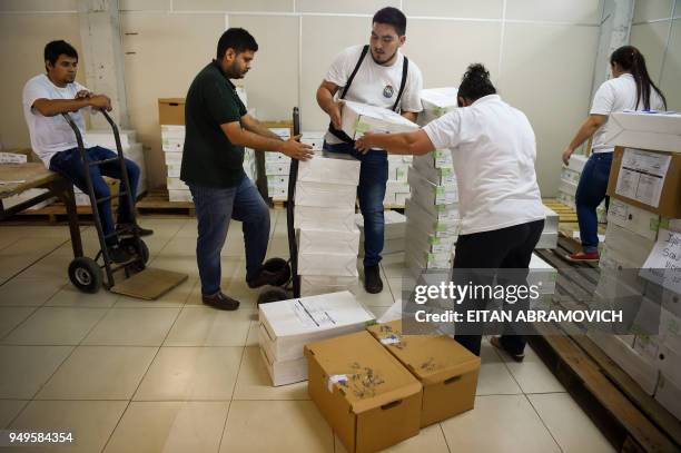 Workers arrange voting material ahead of the upcoming April 22 presidential elections, in Asunción on April 21, 2018. - Opinion polls give the ruling...