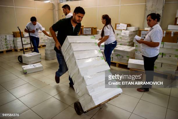 Workers arrange voting material ahead of the upcoming April 22 presidential elections, in Asunción on April 21, 2018. - Opinion polls give the ruling...