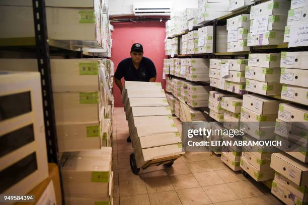 Workers arrange voting material ahead of the upcoming April 22 presidential elections, in Asunción on April 21, 2018. - Opinion polls give the ruling...