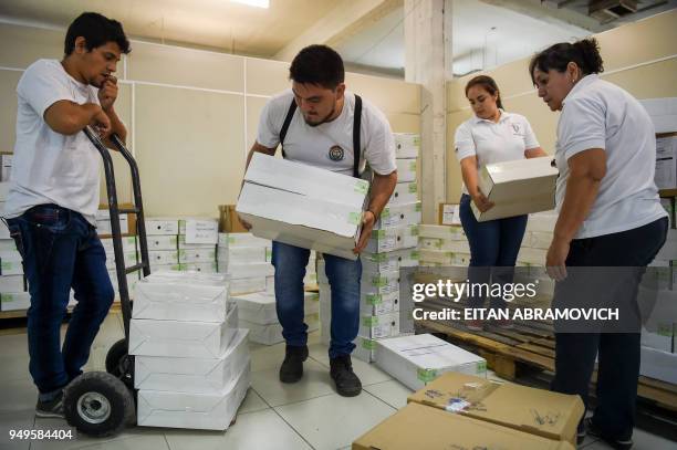 Workers arrange voting material ahead of the upcoming April 22 presidential elections, in Asunción on April 21, 2018. - Opinion polls give the ruling...