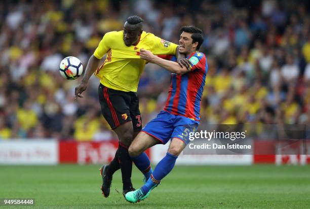 Stefano Okaka of Watford is challenged by James Tomkins of Crystal Palace during the Premier League match between Watford and Crystal Palace at...