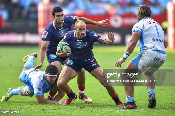 Rebels' Billy Meakes runs as Bulls' Marco van Staden dives to tackle him during the Super Rugby rugby union match between South Africa's Bulls and...