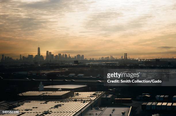 Urban skyline of New York City, New York on a smoggy morning at sunrise, viewed from across an industrial area of Newark, New Jersey, March 18, 2018.