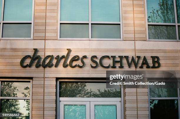 Close-up of sign with logo at Charles Schwab financial adviser branch in Pleasanton, California, March 26, 2018.
