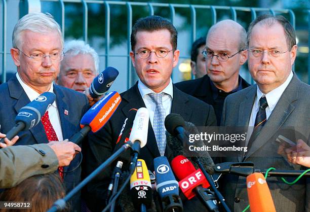 Karl-Theodor zu Guttenberg, Germany's economy minister, center, speaks as Peer Steinbrueck, Germany's finance minister, right, and Roland Koch, prime...