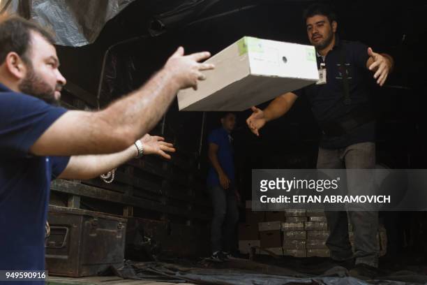 Workers load voting material into a truck ahead of the upcoming April 22 presidential elections, in Asuncion on April 21, 2018. - Opinion polls give...