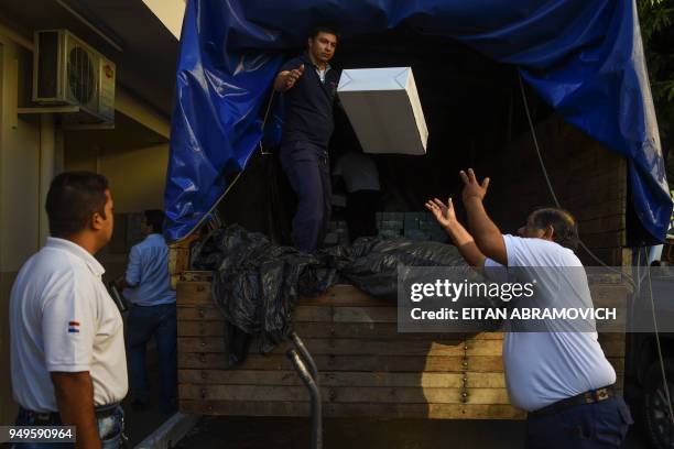 Workers load voting material into a truck ahead of the upcoming April 22 presidential elections, in Asuncion on April 21, 2018. - Opinion polls give...