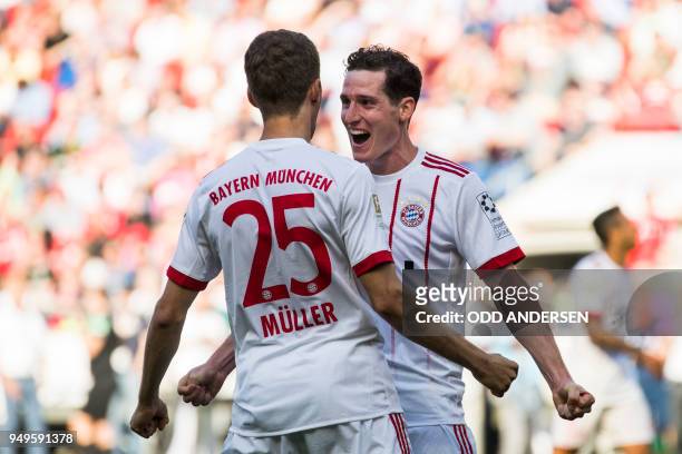 Bayern Munich's German midfielder Sebastian Rudy celebrates scoring his side's third goal with Bayern Munich's German forward Thomas Mueller during...