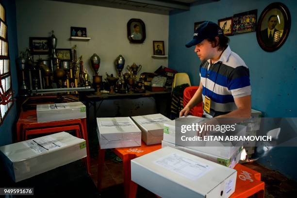 Worker arranges voting material at a polling station ahead of the upcoming April 22 presidential elections, in Asuncion on April 21, 2018. - Opinion...