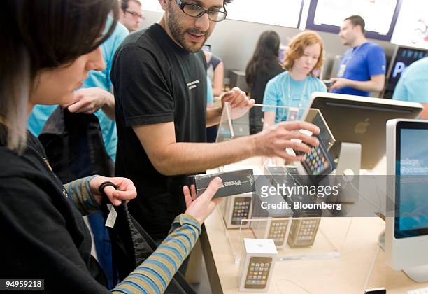 Employees restock the iPhone 3G S at an Apple store in New York, U.S., on Friday, June 19, 2009. Apple Inc. Released a new iPhone today, aiming to...