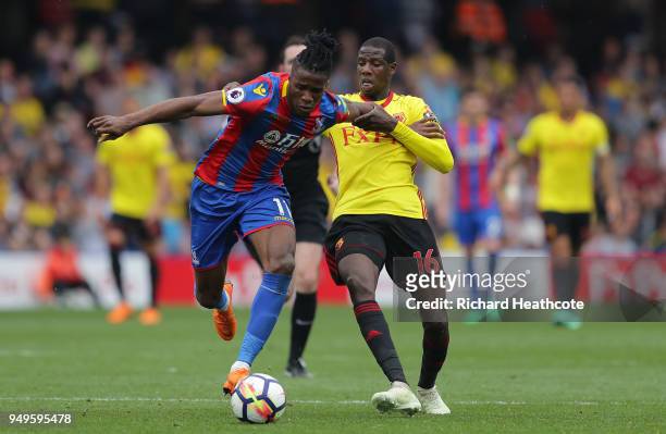 Wilfried Zaha of Crystal Palace is challenged by Abdoulaye Doucoure of Watford during the Premier League match between Watford and Crystal Palace at...