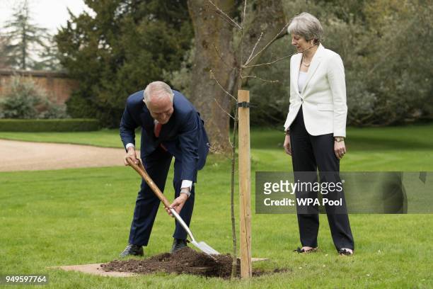 Prime Minister of Australia Malcolm Turnbull plants an English oak tree with Prime Minister Theresa May at her country residence Chequers on April...