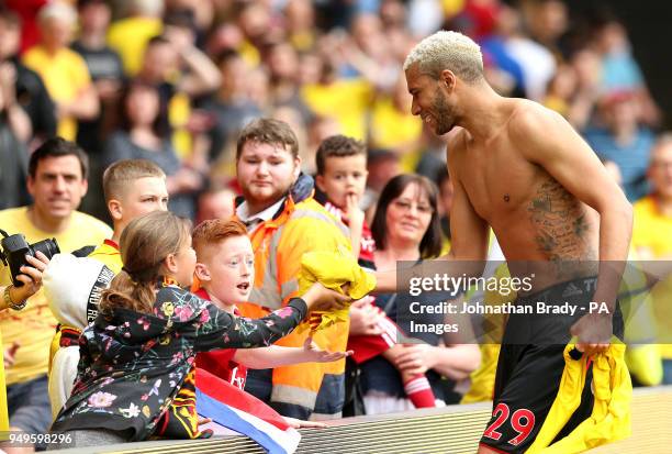 Watford's Etienne Capoue gives away his shirt to a young fan during the Premier League match at Vicarage Road, Watford.