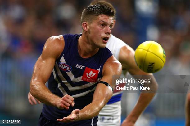 Darcy Tucker of the Dockers handballs during the round five AFL match between the Fremantle Dockers and the Western Bulldogs at Optus Stadium on...