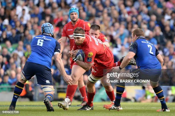 Scarlets' Lewis Rawlins is tackled by Leinster's Australian flanker Scott Fardy and Leinster's Irish hooker Sean Cronin during the European Champions...