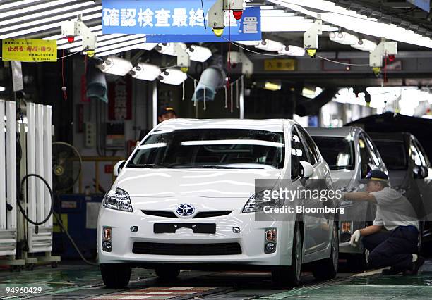 Worker makes a final inspection of Toyota Motor Corp.'s third-generation Prius hybrid vehicle on the production line of the company's Tsutsumi plant...