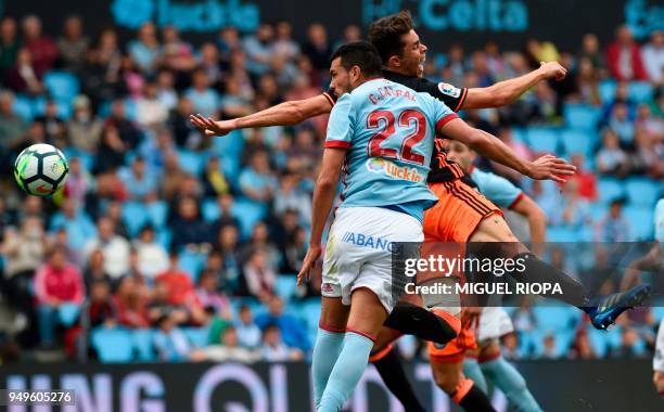 Celta Vigo's Argentinian defender Gustavo Cabral heads the ball next to Valencia's Brazilian defender Gabriel Paulista during the Spanish league...