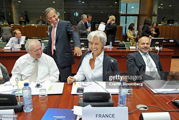Christine Lagarde, France's finance minister, seated center, laughs with Charilaos Stavrakis, the finance minister of Cyprus, standing, as Eduard...