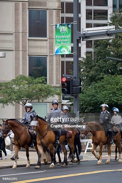 Police officers patrol on horses near the David L. Lawrence Convention Center before the start of the Group of 20 summit in Pittsburgh, Pennsylvania,...