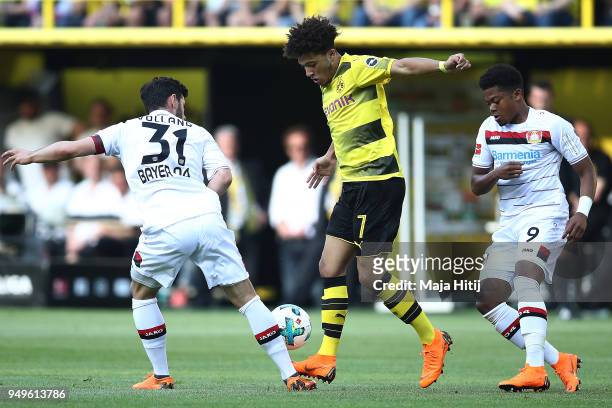Jadon Malik Sancho of Dortmund fights for the ball with Kevin Volland of Bayer Leverkusen and Leon Bailey of Bayer Leverkusen during the Bundesliga...